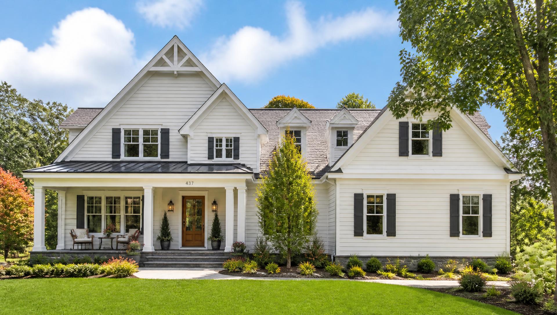 Freshly painted American home exterior with white trim, blue sky, and green lawn